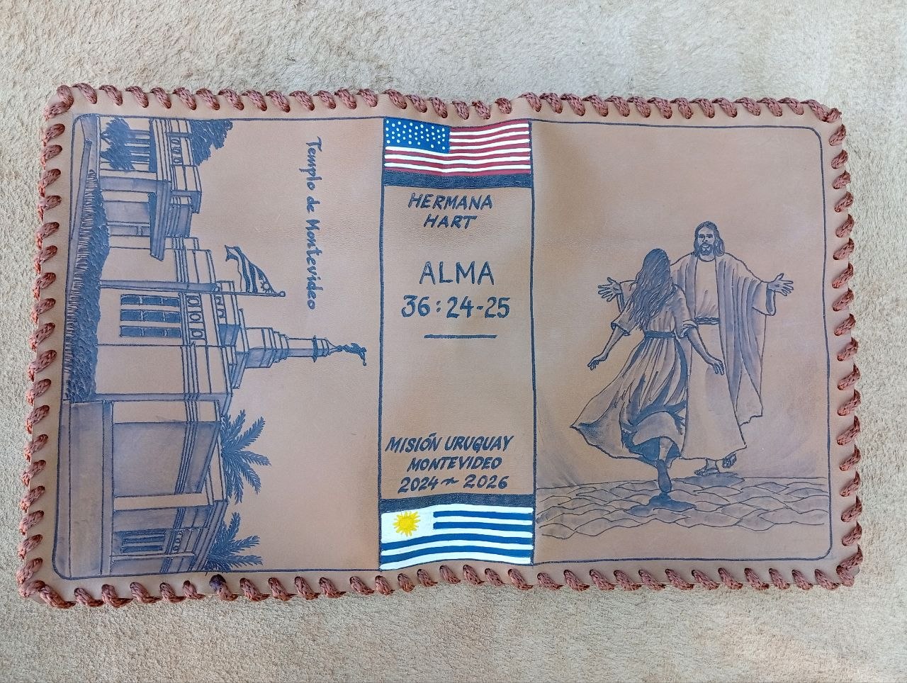 Hand-laced cowhide mission cover with the Montevideo Temple, Christ walking with a sister, US and Uruguay flags, Alma 36:24-25, and Misión Uruguay Montevideo 2024–2026