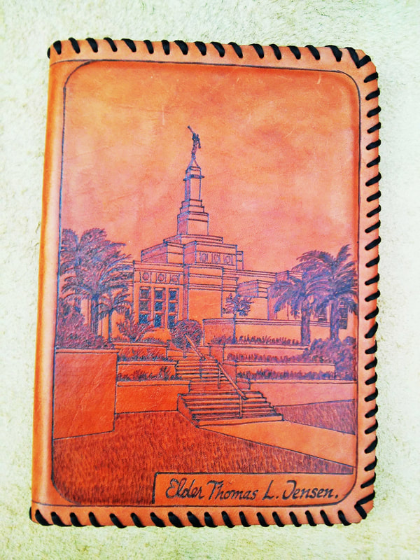 Orange leather cover with a pyrography of a temple and palm trees