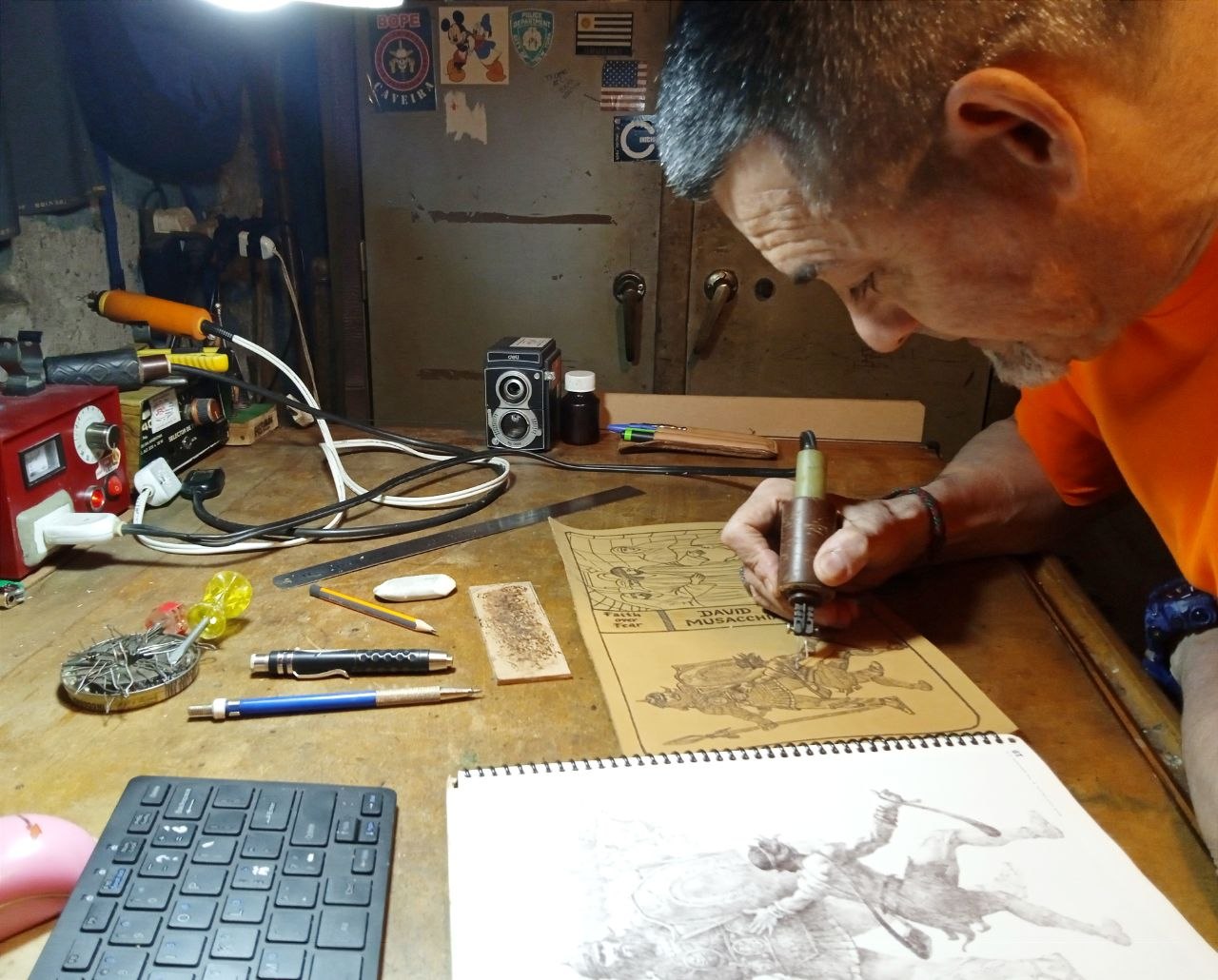 Juan Pedro burning a pyrography drawing at his workbench in Montevideo