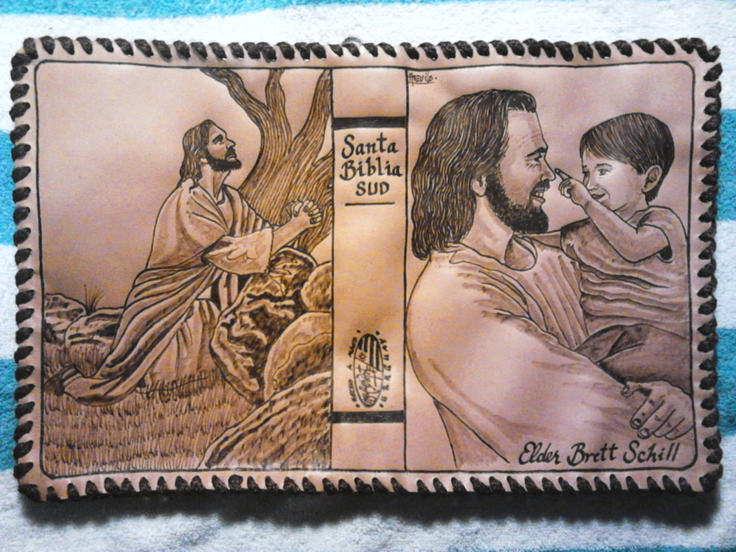 Leather Bible cover with a kneeling figure and a portrait of a man holding a child