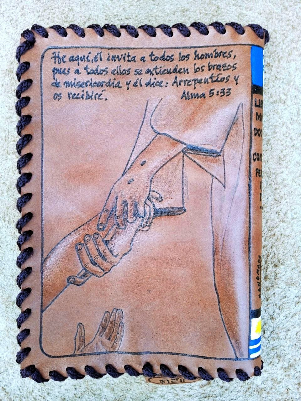 Leather cover showing clasped hands and a handwritten Spanish verse