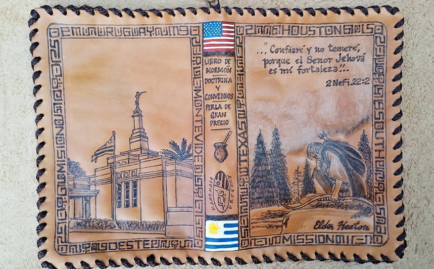 Leather scripture cover with a temple, US and Uruguay flags, pine trees, and a kneeling figure