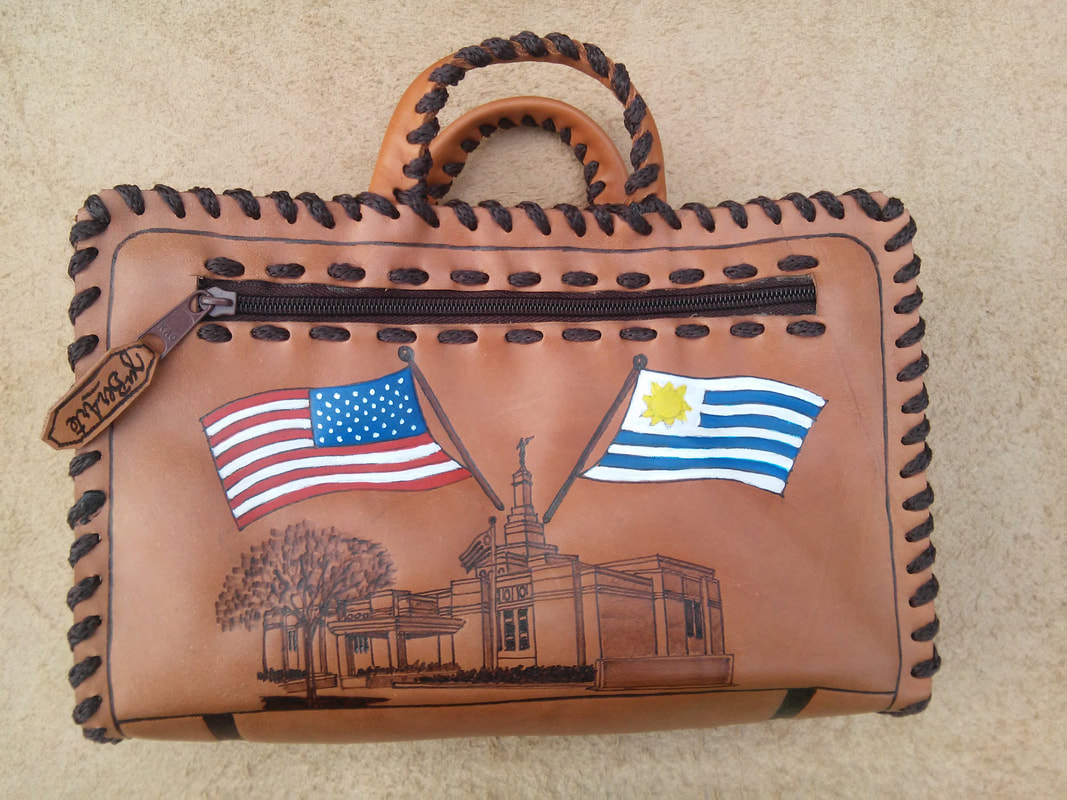 Hand-laced leather bag with US and Uruguay flags and a temple drawing