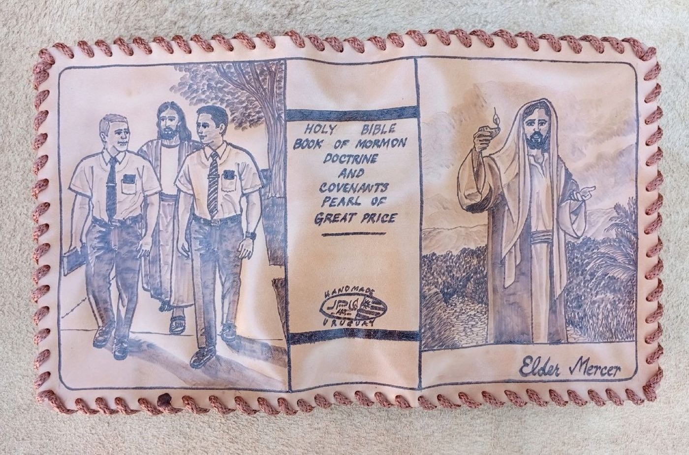 Hand-laced cowhide scripture cover with two missionaries walking beside Christ, Christ holding a lamp in a mountain landscape, and the name Elder Mercer
