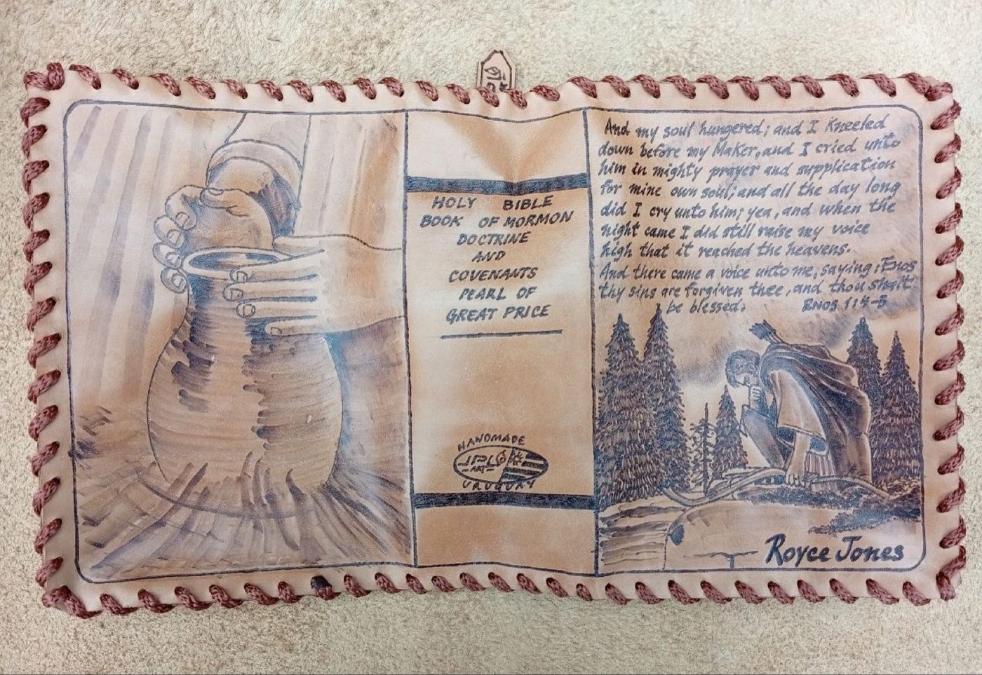 Hand-laced cowhide scripture cover with hands holding a cup over a vessel, Enos 1:4–5, a kneeling figure among pines, and the name Royce Jones